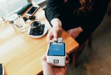 person using a credit card for payment on a coffee table
