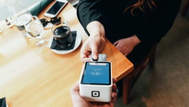 person using a credit card for payment on a coffee table