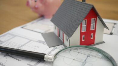 Magnifying glass over miniature house model and blueprints- Texas property tax appraisal protest guide - Texas Financial Report
